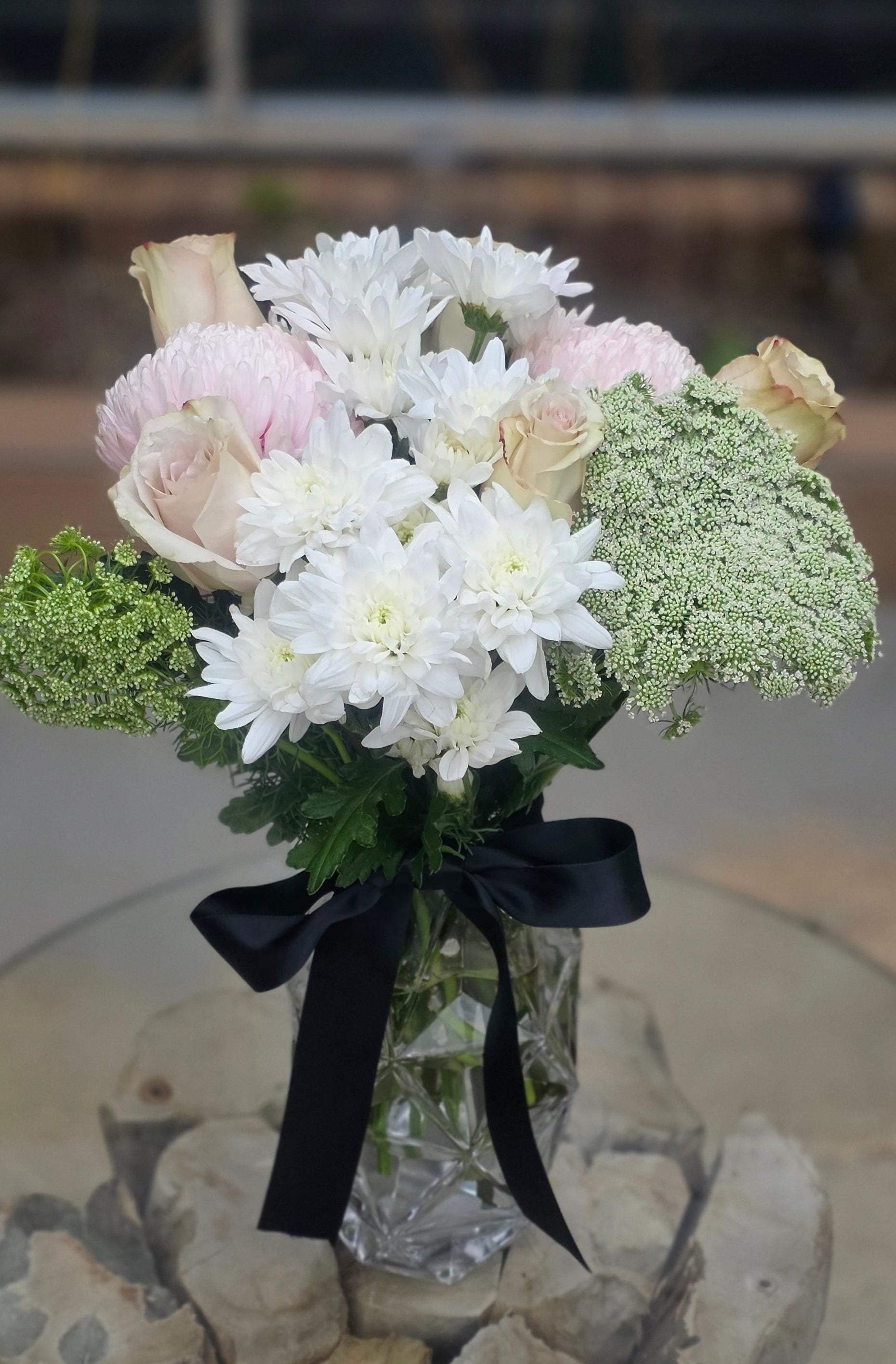 Bouquet of flowers with a black ribbon in a glass vase